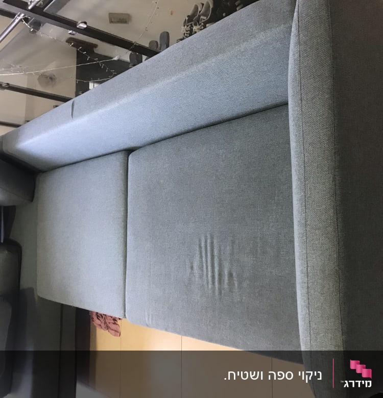 ספה אפורה עם כריות על רצפה בהירה